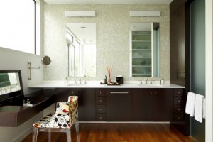 L shaped vanity with wooden cabinet, white countertop with two sinks, medicine cabinet mirror, makeup area with convertible mirror