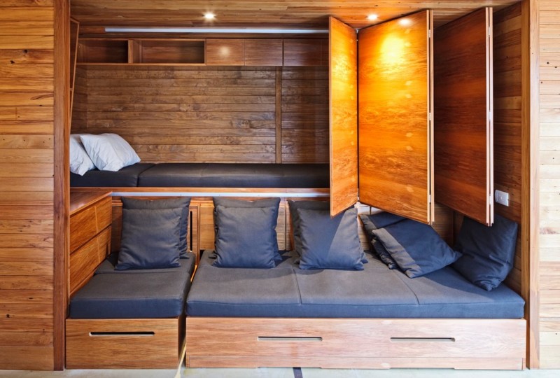guest bed idea wooden walls pillows folding doors beach style bedroom ceiling lights