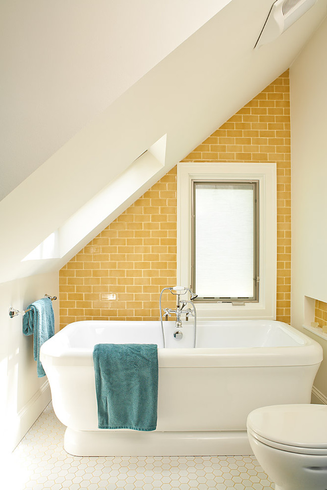 small bathroom with yellow subway tiles wall, mosaic hexagon tiles flooring, white toilet, small white bathtub