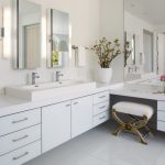 White Bathroom With White Ceiling, Wall, Flooring, L Shaped Vanity With White Cabinet Under, White Double Adjoint Sink, Three Mirrors, Sconces