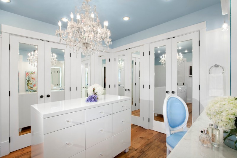 white cabinets medium tone hardwood floors beautiful light blue ceiling with crystal chandelier in walk in closet marble countertop dresser