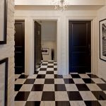 Ornate Entryway With A Black Front Door, Marble Floors And Multicolored Floors White Painted Brick Wall Black And White Artworks White Chandelier Lamp