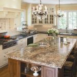 classic l shaped kitchen with beaded inset cabinets, stainless steel appliances, a drop in sink, white cabinets, laminate countertops, white backsplash and subway tile backsplash