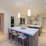 Large Transitional U Shaped Eat In Kitchen With An Undermount Sink, Flat Panel Cabinets, Gray Cabinets, Quartz Countertops, White Backsplash, Porcelain Floors, Multiple Islands And Stainless Steel Appl