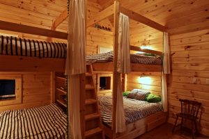 queen size bunk beds lodge bedroom natural wood bunk beds black and white stripe bed sheets and pillow cover whitebed curtain with green tassels built in wood ladder