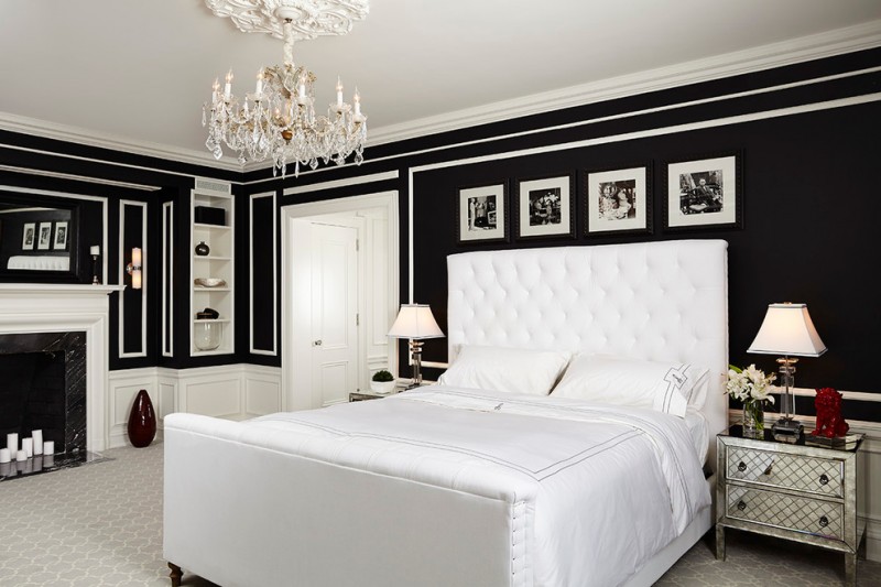 classic carpeted bedroom with black walls and white trim, a standard fireplace and a wood fireplace surround chandelier lamp table lamps metallic cabinets