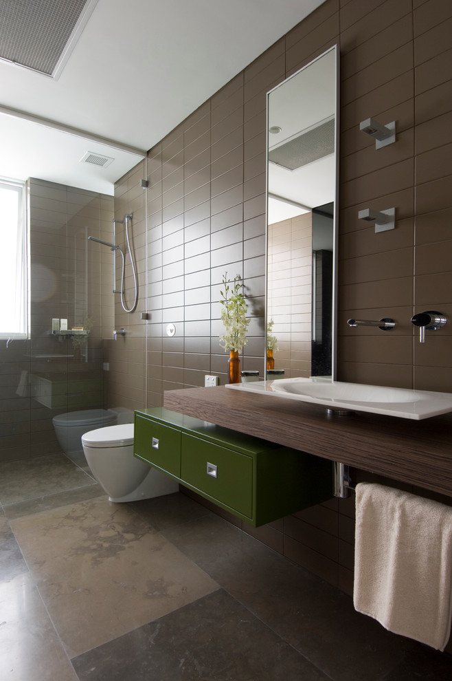 brown bathroom brown limestone floor and wall tiles dark wood countertop floating vanity glass shower green drawers handheld shower head Large bathroom mirror