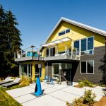 Modern Awning Yellow And Brown House Outdoor Furniture Blue Chairs Black Glass Windows And Doors Patio Small Garden