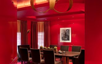 red dining room wood floor red wall and ceiling chandelier red curtains pink valances brown dining table and chairs artwork