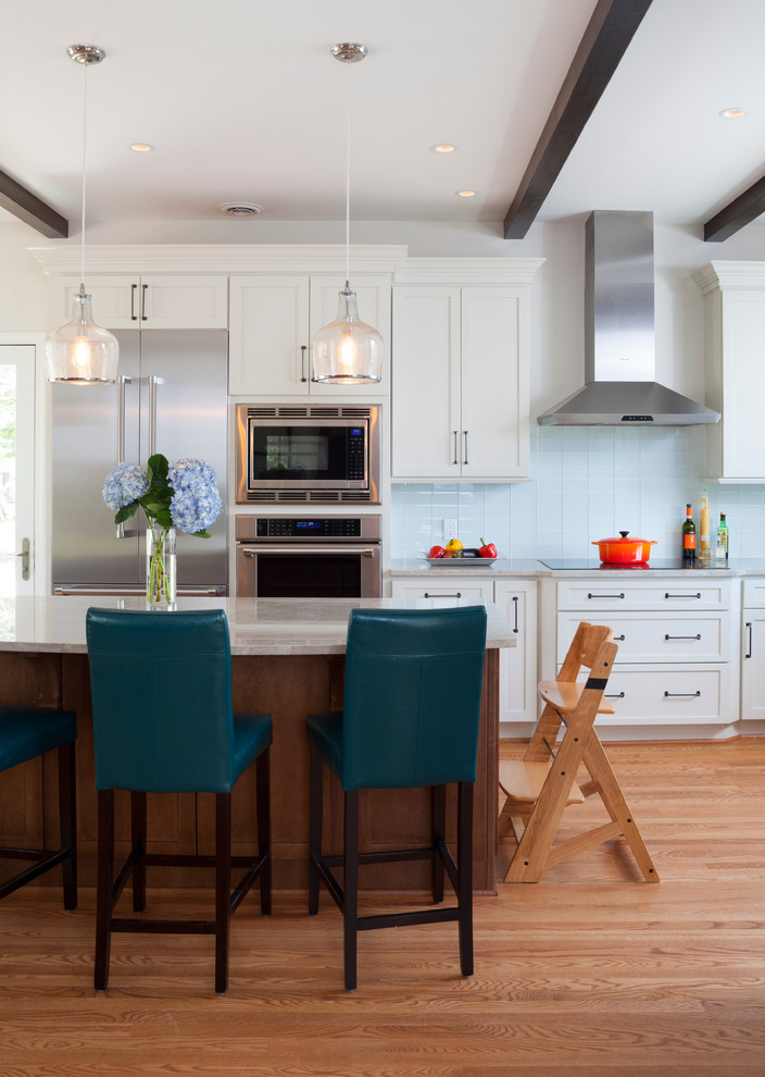 teal and brown barstools wood flooring white kitchen cabinets wood kitchen island with white countertop wood beams pendants