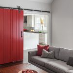 Red Door Designs Barn Door Grey Sofa Wooden Table Grey And Red Throw Pillows White Kitchen Cabinets Black Granite Countertop