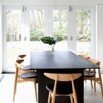 Black Dining Table Wooden Dining Table With Black Leathered Cushions White Industrial Pendant Lamps White Floor Tile White Framed Glass Doors