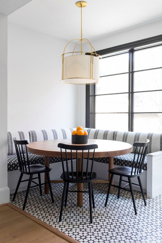 corner dining set with round wooden table, black metallic chair, striped corner bench
