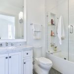 Frameless Hinged Tub Door Wall Mirror White Vanity White Marble Top And Backsplash Built In Tub White Wall Tile Black Hexagon Floor Tile