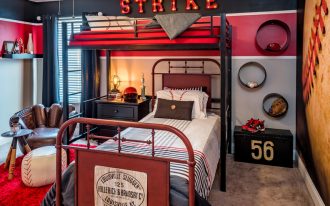 kids bedroom with brown rug, black wall with baseball wallpaper, ball ottoman, glove chair, coffee table with bats feet, two beds, metal bedding