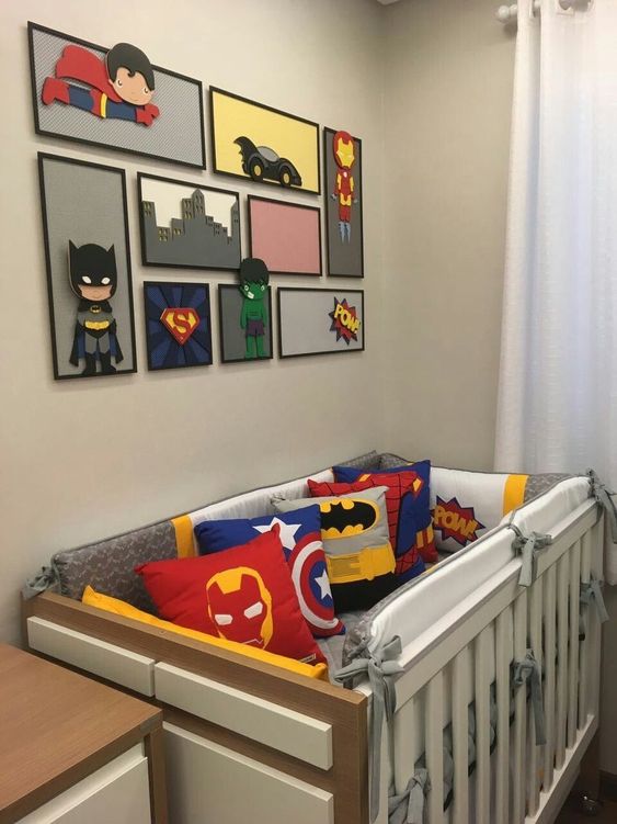 baby crib with superhero pillows, superheroes wall decor