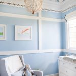 Nursery With Wooden Floor, Rug, Chair, Baby Changing Station, Blue Wall, Ceiling With Birds Picture, Chandelier