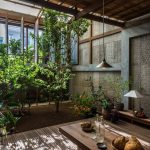 Open Dining Area With Wooden Floor, Wooden Table, Wooden Stools, Plants Outside