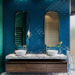 White Sink With Wooden Cabinet, Terrazzo Counter Top, Terrazzo Flooring, Deep Blue Scale Tiles On The Wall With Gold Framed Mirrror