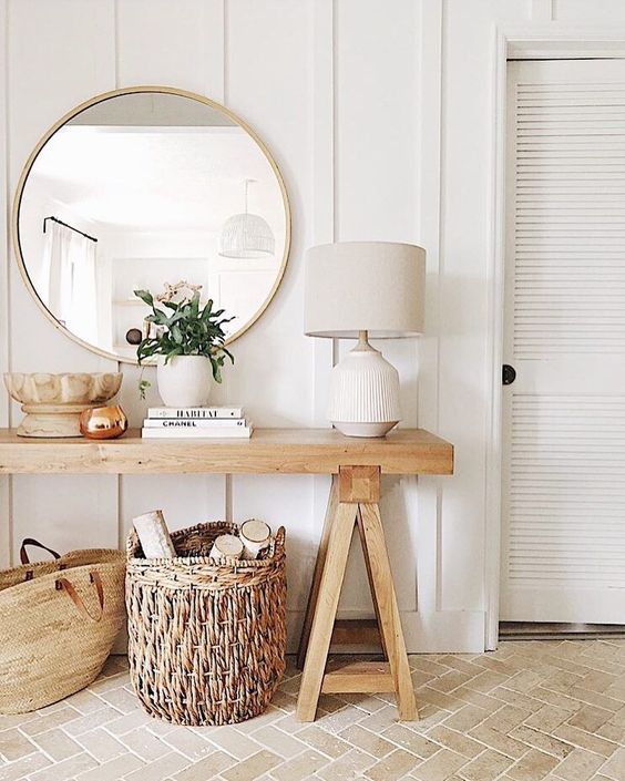 wooden simple bench table with white lamp, rattan basket, bag, round wall mirror
