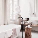 Bathroom, White Marble Floor, White Wall, Wooden Floating Shelves, White Sink, Mirror, White Rub, Black Faucet, Windows With Curtain