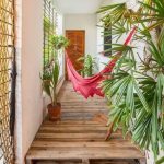 Pink Hammock With Fringe In The Hall With Wooden Platform Floor, White Wall