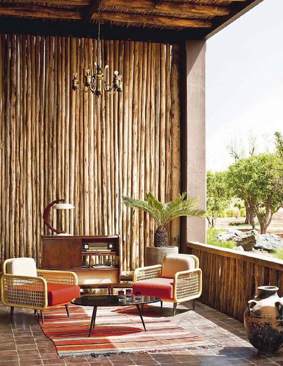 wooden covering wall on the porch, earthy floor tiles, rug, wooden chairs, coffee table, cabinet, chandelier