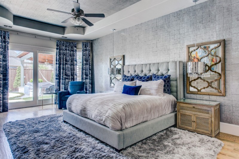blue and gray bedroom grey wallpaper grey shag rug blue curtains grey bed grey bedding blue pillows wall mirror traditional nightstand blue armchair ceiling fan with lamp