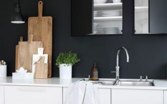 kitchen, wooden floor, white cabinet, black wall, black built in upper cabinet, black pendant, white top