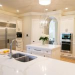 White Marble Kitchen Backsplash, White Upper And Bottom Cabinet, Brown Tiles, White Counter Top White Pendants, Chandelier, Middle Island
