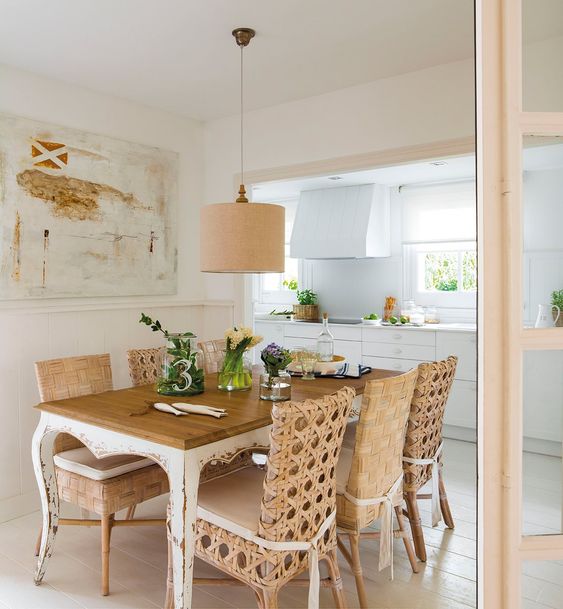 dining room, wooden floor, wooden table rattan chairs, brown pendant, white wall, white kitchenette