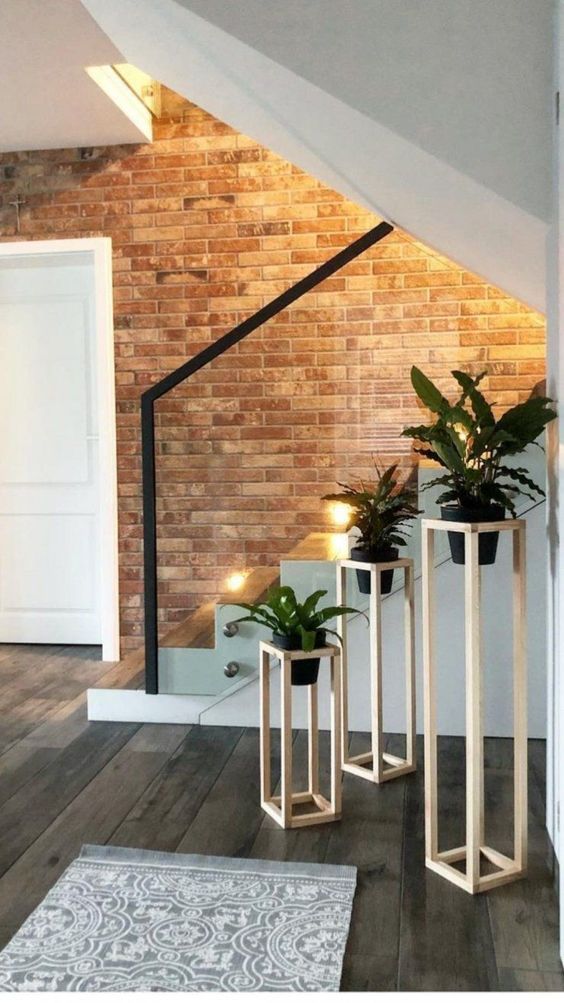 entrance, white plant supports, wooden floor, open brick wall, white door, grey mat