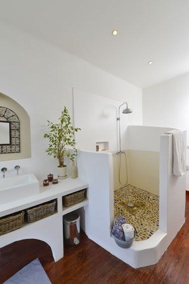 greek bathroom, wooden wall, tiles inside, half partition, white built in vanity, white sink, mirror