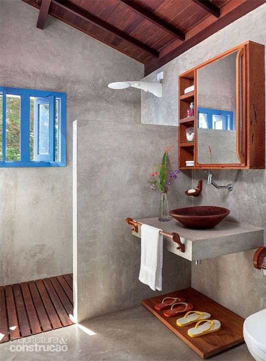 minimalist bathroom, grey surface on floor, wall, partition, floating vanity, brown earthen ware sink, floating cabinet with mirror, wooden floor, blue framed window