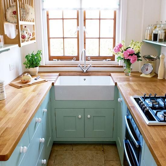 small kitchen, green bottom wooden cabinet, white wall, wooden top, wooden framed window, wooden floating shelves