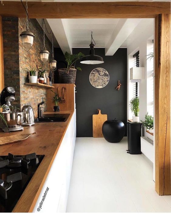 kitchen, white floor, black wall, brown tiles wall, white cabinet, wooden top, black pendant, rustic pendant