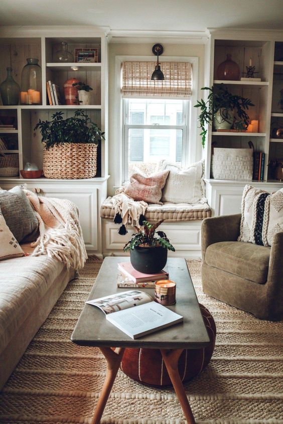 living room, brown rug, white wall, white ceiling, white shelves, white window bench with brown cushion, brown sofa, brown chair, coffee table, red ottoman