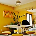 Open Dining Room, White Round Rug, Grey Floor Tiles, Yellow Wall White Ceiling, White Tulip Table, Yellow Stools