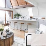 Open Kitchen, Wooden Floor, White Sloping Wall, White Ceiling, Wooden Vaulted Ceiling, Round Wooden Table, White Chair, Wooden Stools