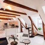 Open Room Under The Attic, Small Kitchen, White Dining Set, Living Room, White Chair, Black Chair, White Floor, Firepace, Wooden Beams