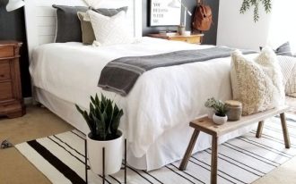 bedroom, brown rug floor, white wall, black wall, white headboard, wooden bench, wooden bedside cabinet,