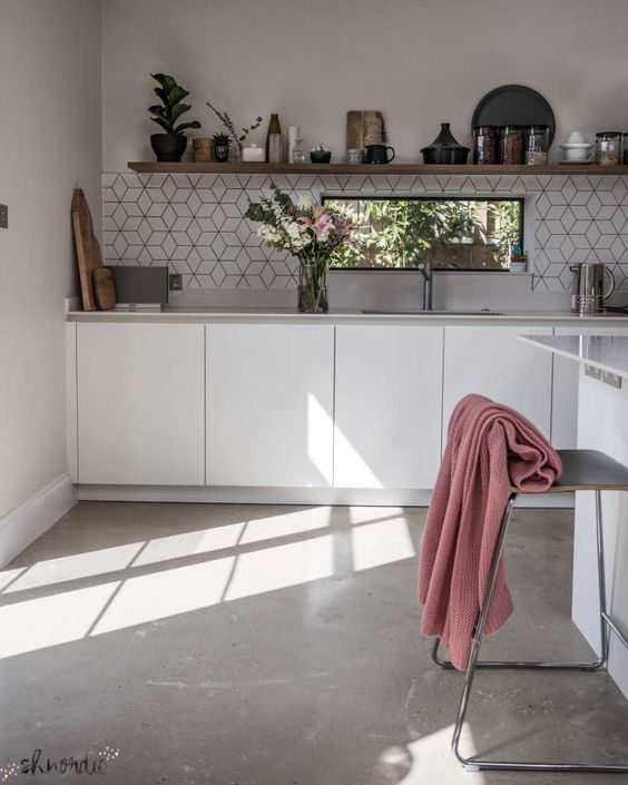 kitchen, concrete floor, white wall, white bottom cabinet, hexagonal backsplash, white island, floating wooden shelves