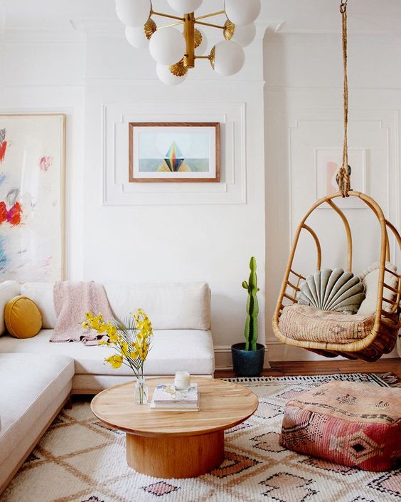 living room, wooden floor, white wall, white sofa, round wooden coffee table, rattan swing, white pendant