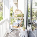 Rattan Swing In The Balcony, White Fence, White Side Table, Grey Floor