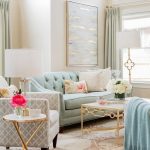 Living Room, Pink Patterned Rug, Blue Tufted Sofa, Grey Chairs, Golden Framed Side Table, White Coverred Table Lamp, Golden Framed Coffee Table, White Covered Floor Lamp