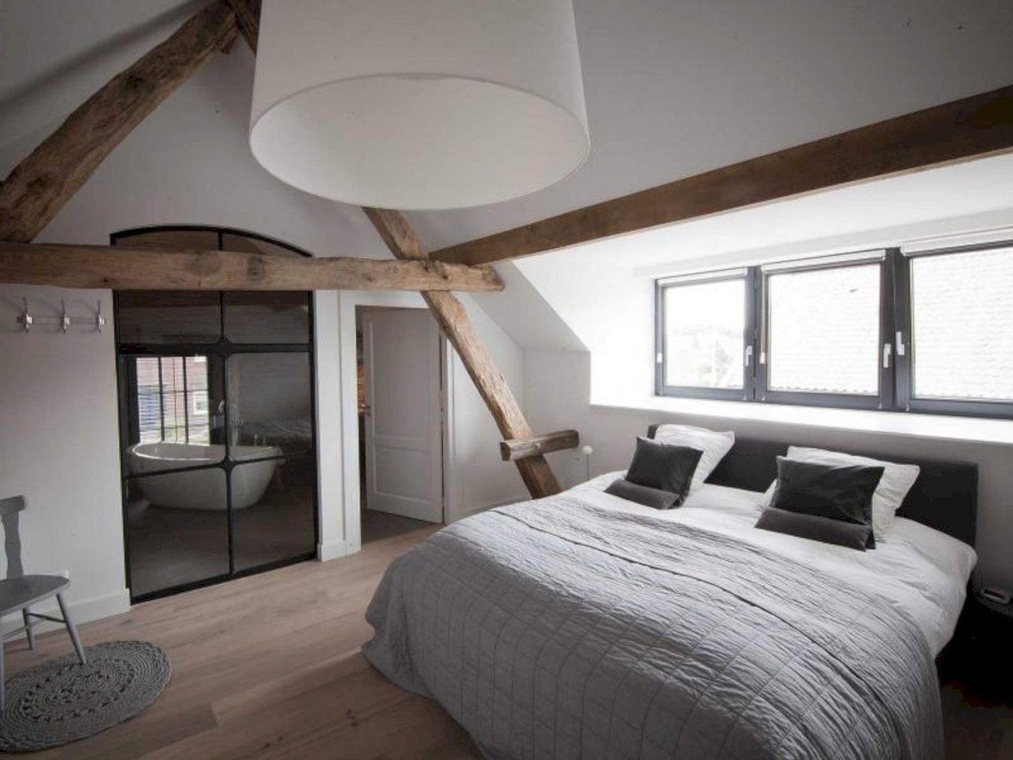 bedroom, wooden floor, white wall, vaulted ceiling, black bed platform, wooden beams
